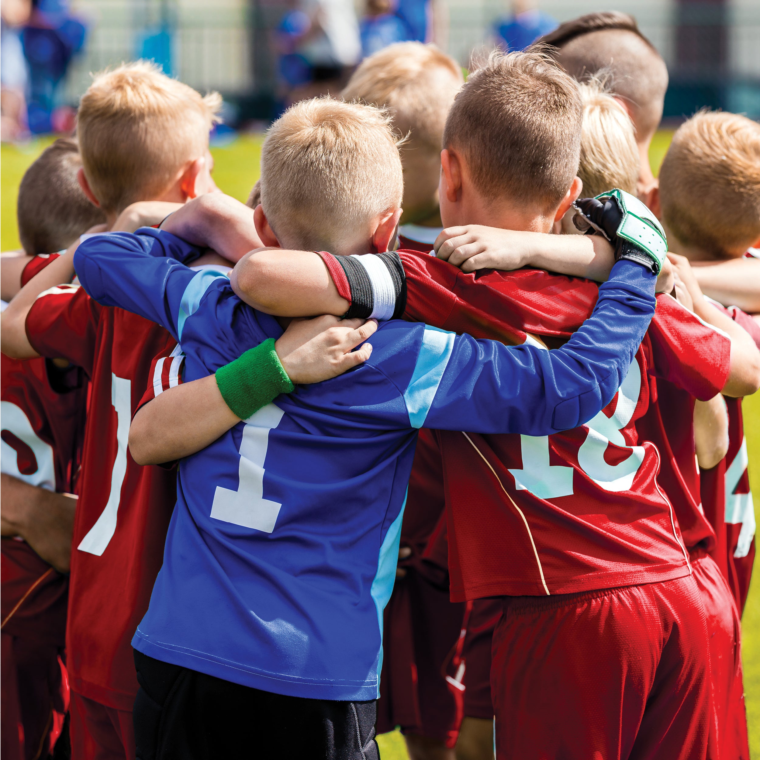 Kids in a hundle at a football match prior to game starting having a pep talk.